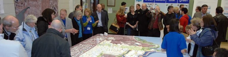 Photo of people standing around a large model.