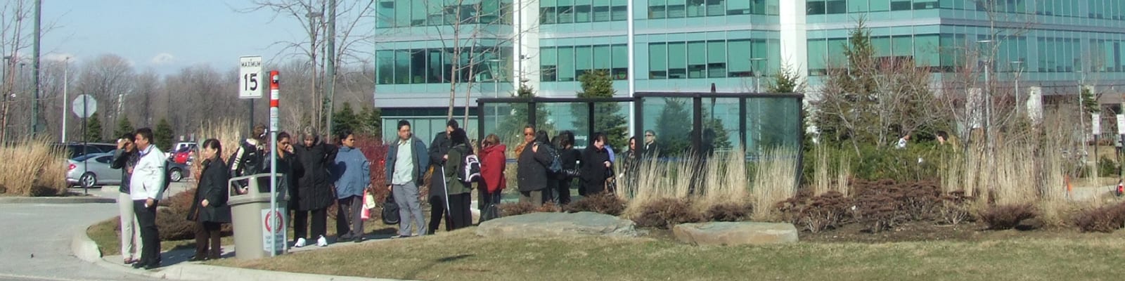 Photo of people waiting outside for a bus.