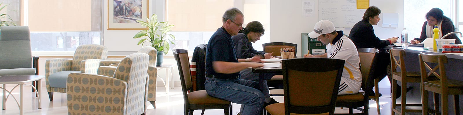 Photo of people sitting at tables and drawing.