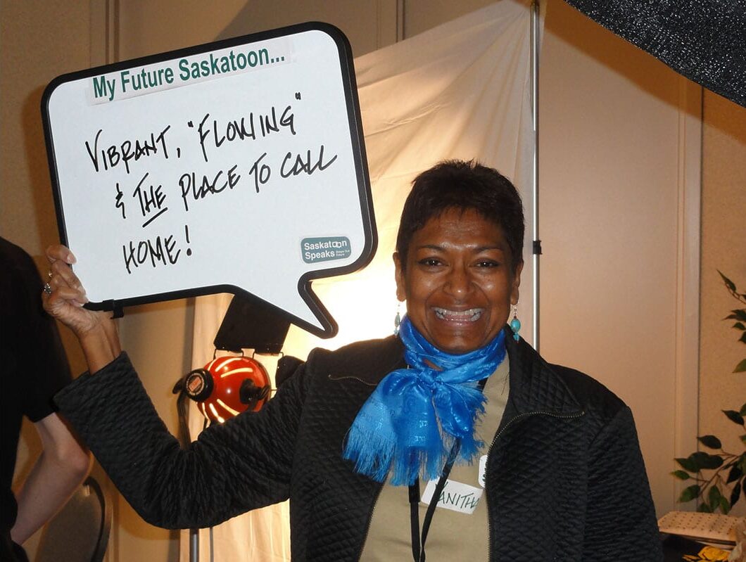 Photo of a person holding a sign that says "My future Saskatoon: vibrant, flowing, and the place to call home!".