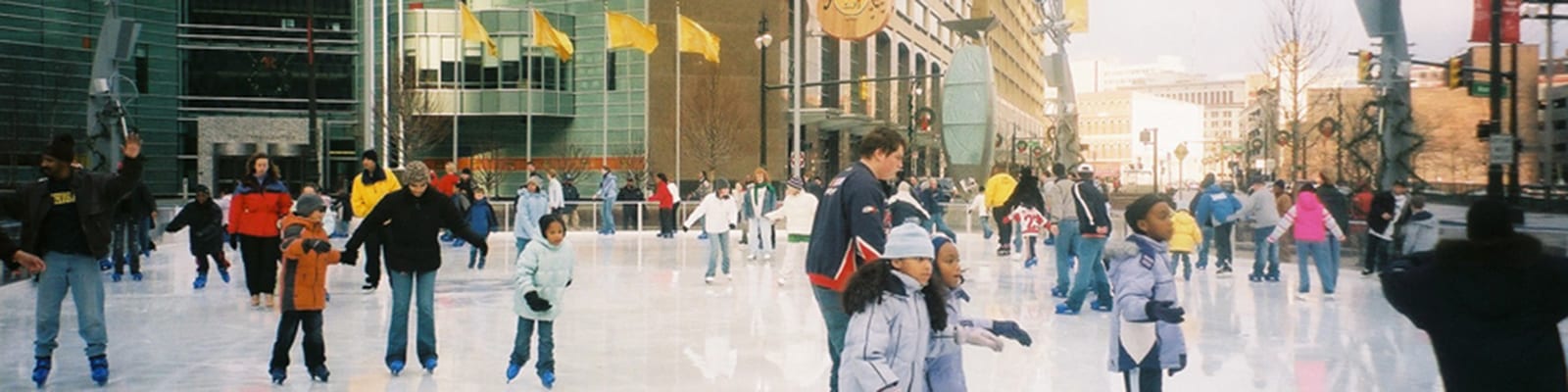 Photo of people skating on an outdoor city rink.