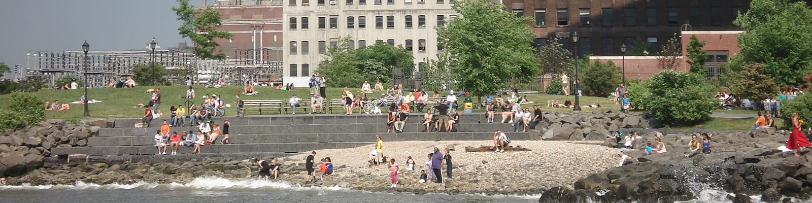 Photo of people standing and sitting on a beach.