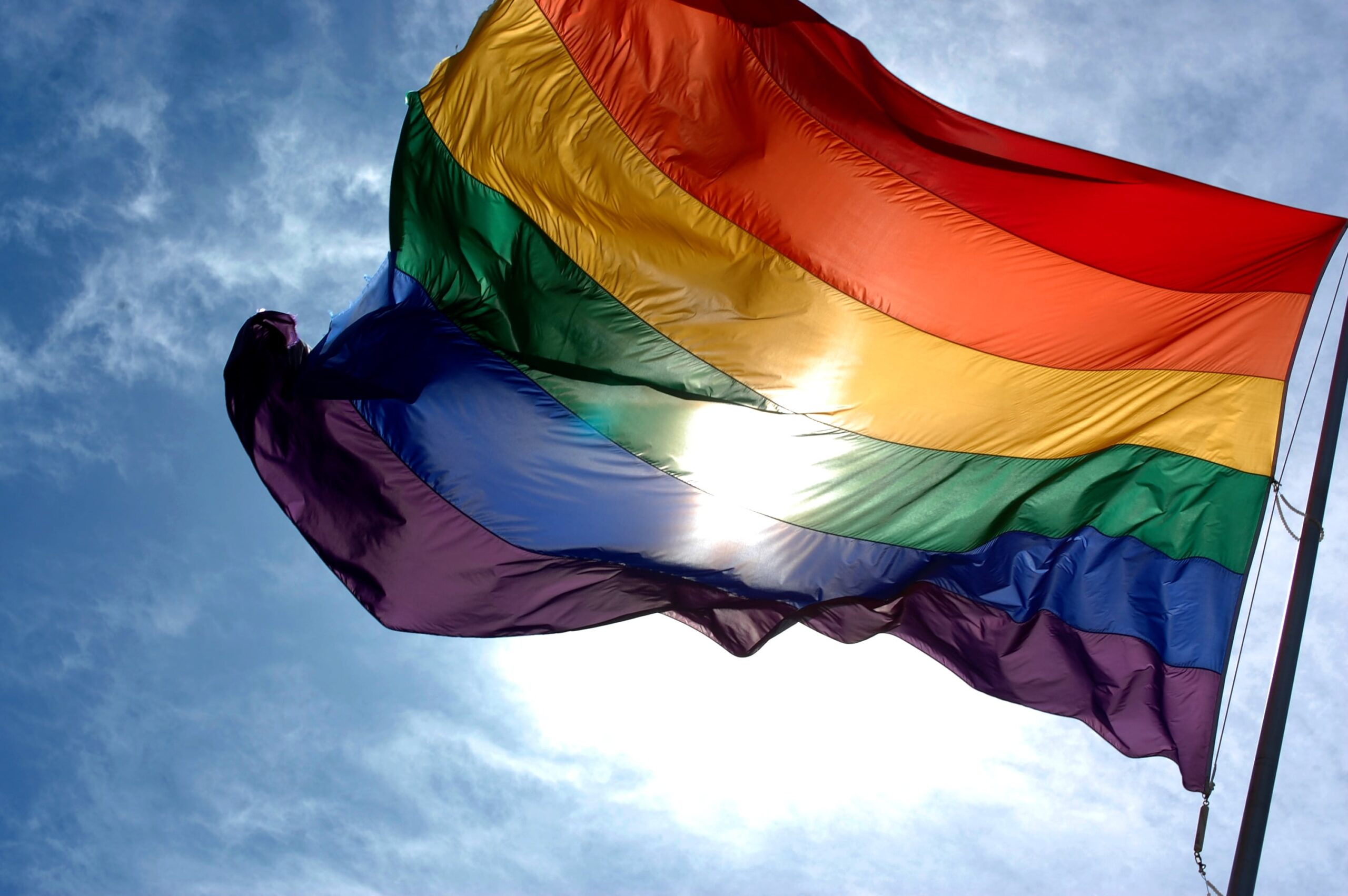 LGBTQIA2S+ flag blowing in the wind.