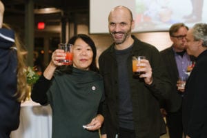 Two people holding drinks and smiling.